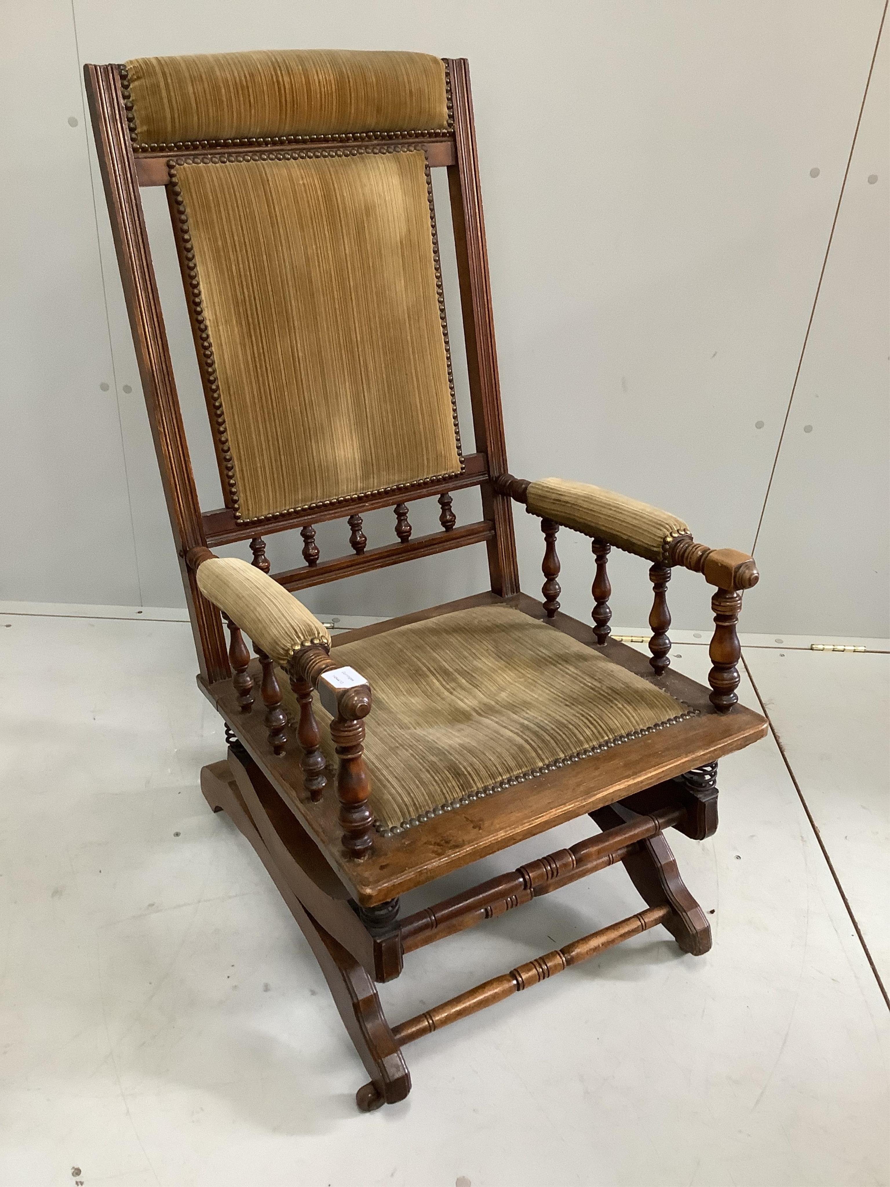 A late 19th century American oak and beech upholstered rocking chair, width 58cm, depth 54cm, height 106cm. Condition - fair